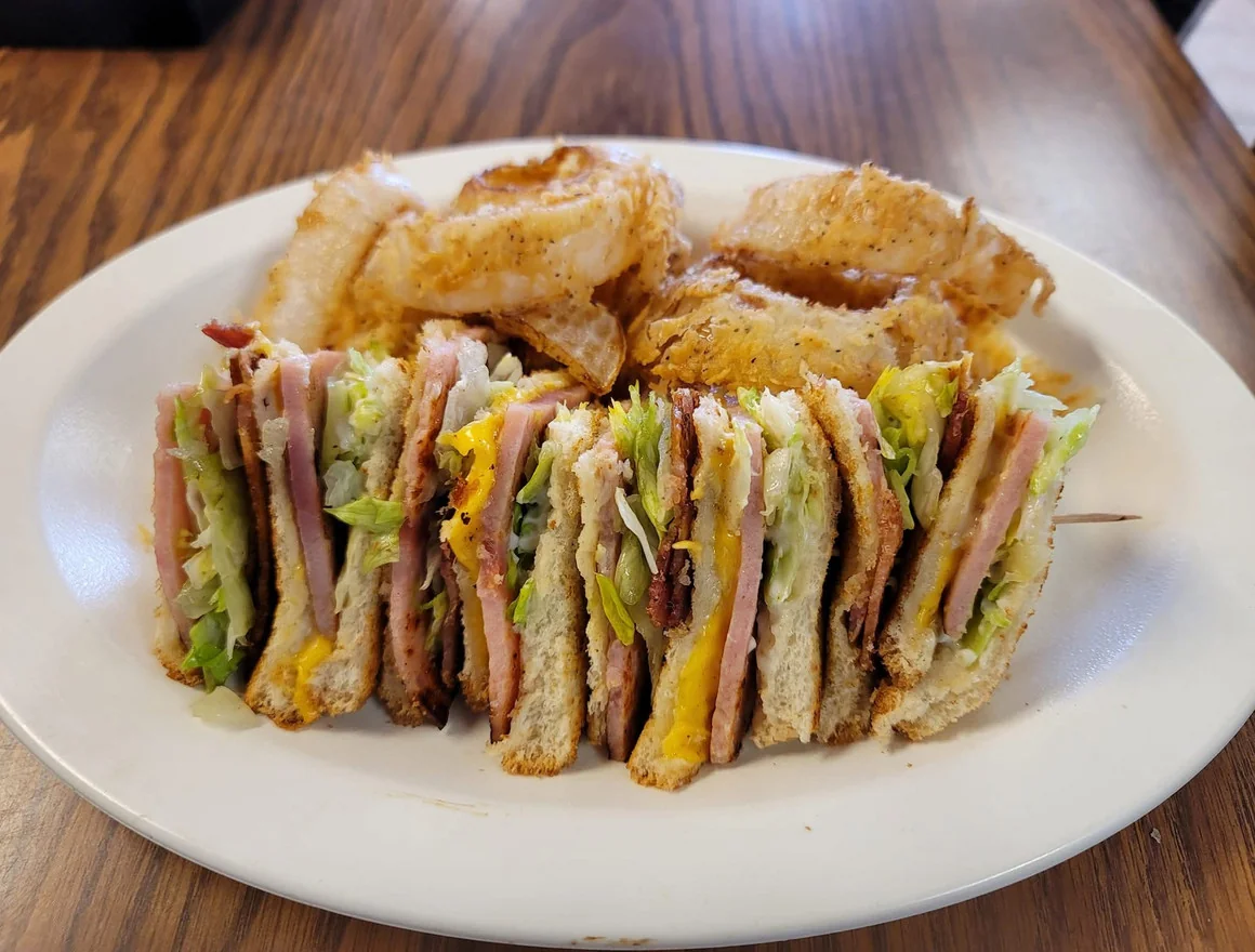 Club Sandwich & Onion Rings - Triple-decker club sandwich with crispy onion rings.
